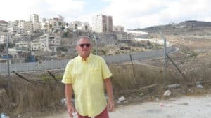 Gerd Bohne in Jerusalem vor der monströsen Mauer im Hintergrund